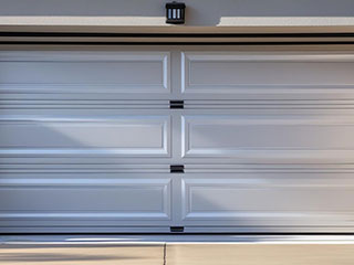 White overhead garage door in Flushing, NY, maintained for safety and performance.